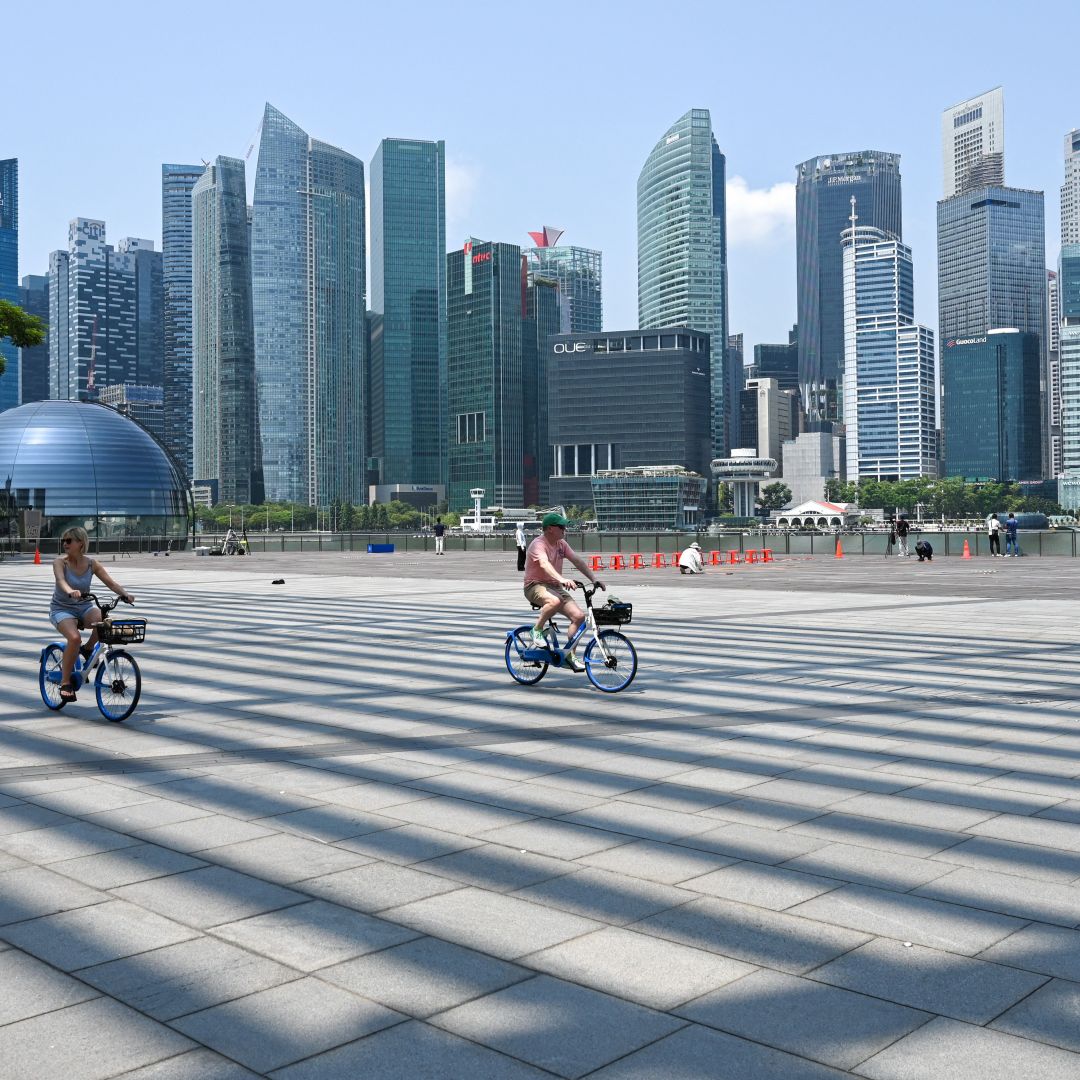 People cycle along the promenade at Marina Bay in Singapore on Oct. 13, 2023. 