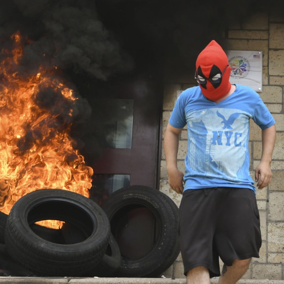 A tire fire burns at the doors to the outer entrance of the U.S. Embassy in Tegucigalpa on May 31, 2019.