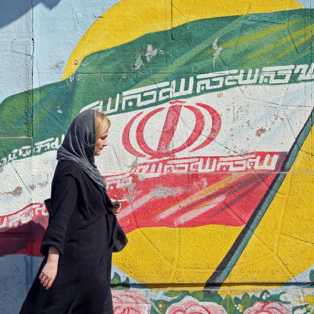 A pedestrian walks past a mural depicting the Iranian national flag in Tehran, Iran. A pedestrian walks past a mural depicting the Iranian national flag in Tehran, Iran.