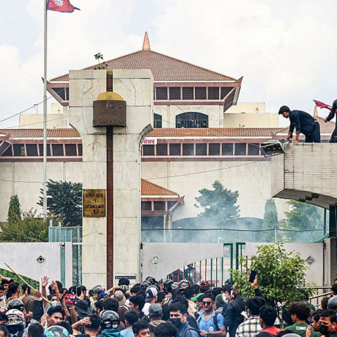 Demonstrators carrying Nepal's national flag stage a protest outside the parliament building in Kathmandu on Sept. 8, 2025, against social media prohibitions and government corruption.