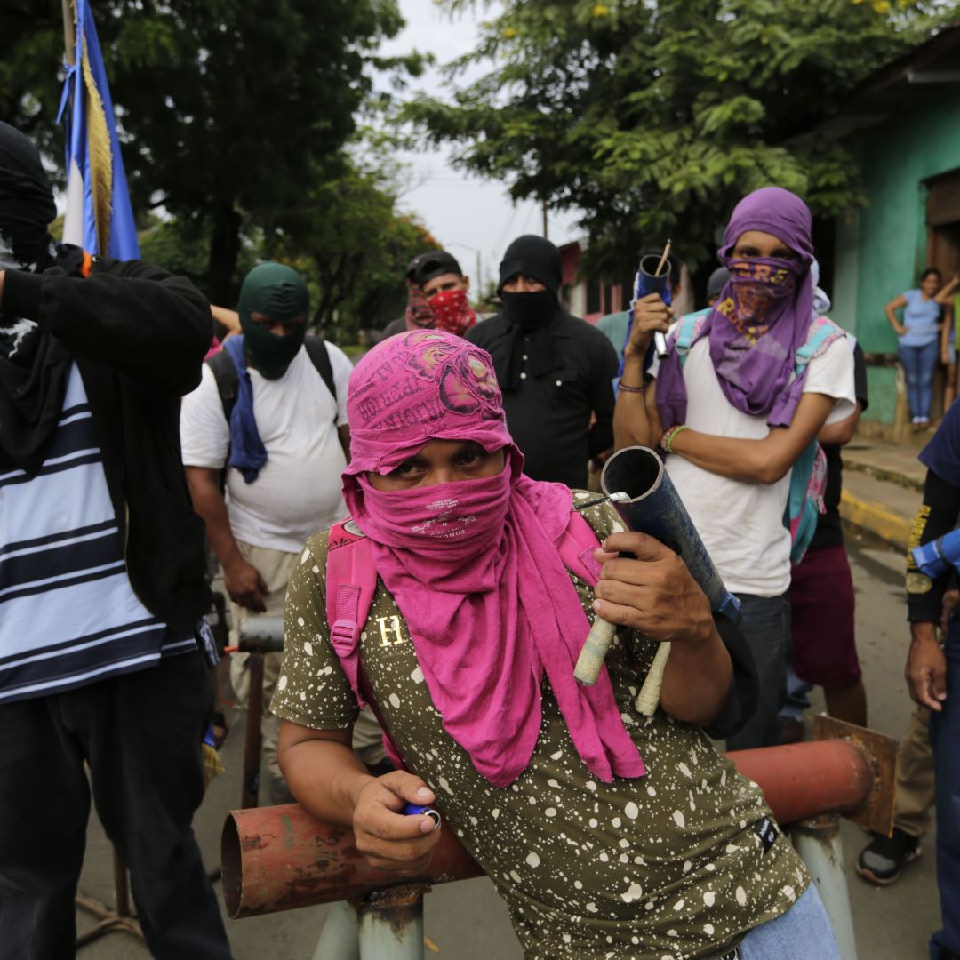 Anti-government demonstrators carry homemade mortars, as they stand near a barricade in Masaya, Nicaragua, on June 5.